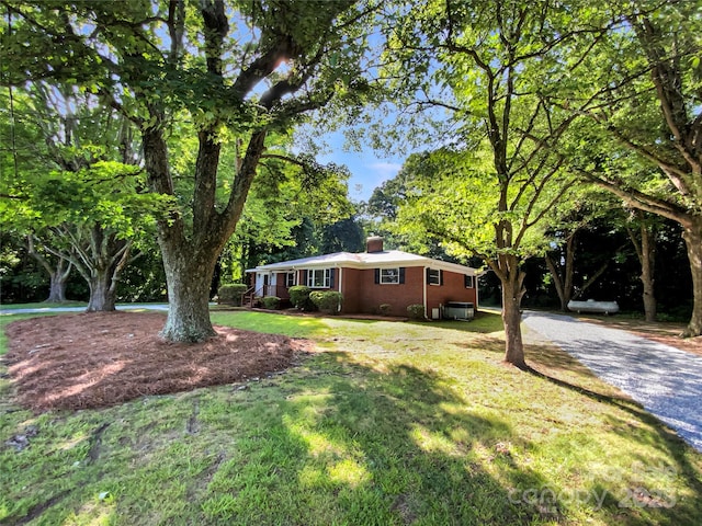 7812 Old Concord Rd, Salisbury, NC 28146 - view of front of house featuring a chimney, brick siding, a front lawn, and view of scattered trees