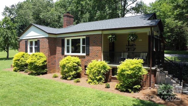 107 Byrd St, Morganton, NC 28655 - view of front of property featuring a front yard, a chimney, brick siding, and a shingled roof