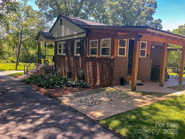 107 Byrd St, Morganton, NC 28655 - view of front facade with brick siding, a patio area, and stairs