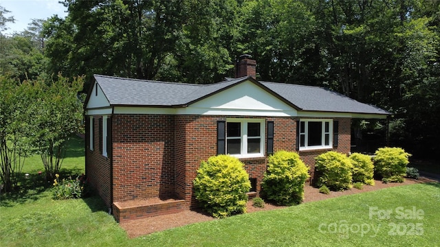 107 Byrd St, Morganton, NC 28655 - view of home's exterior featuring a yard, brick siding, a chimney, and a shingled roof