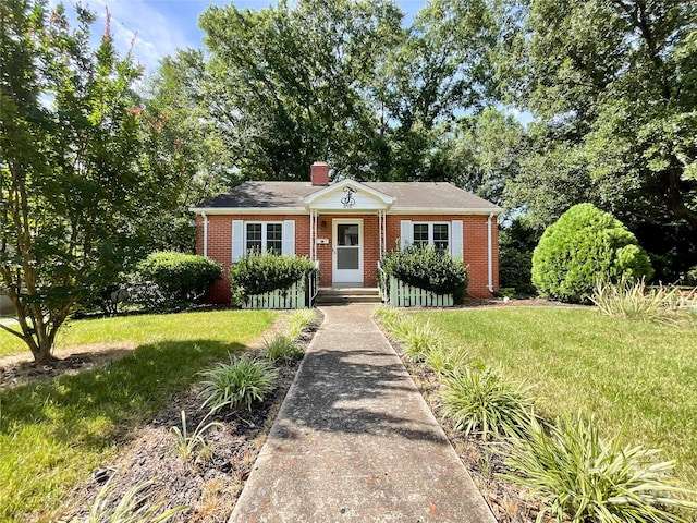 310 E Houston St, Monroe, NC 28112 - bungalow with brick siding, a front yard, and a chimney