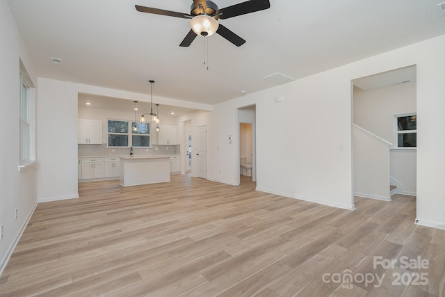 318 Sixth St, Belmont, NC 28012 - unfurnished living room with light wood-style flooring, ceiling fan, and stairway