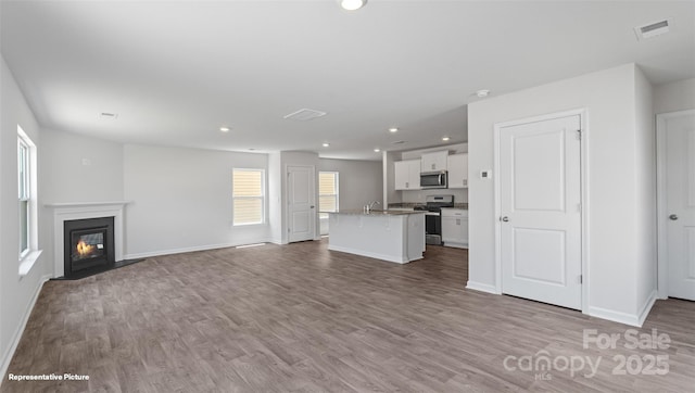 514 13th Avenue Dr NE, Hickory, NC 28601 - unfurnished living room featuring healthy amount of natural light, recessed lighting, wood finished floors, and a fireplace with flush hearth