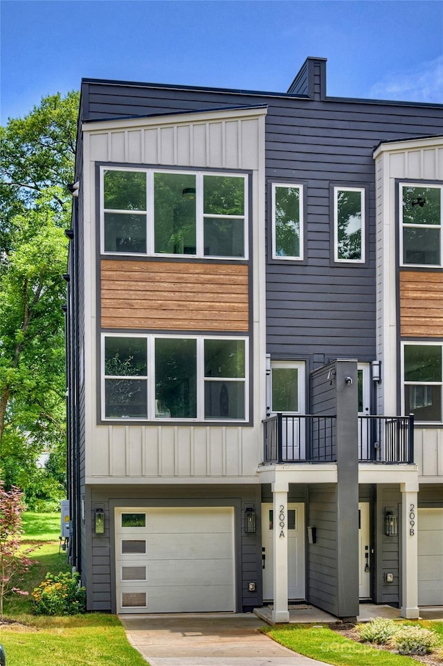209 Coxe Ave Unit A, Charlotte, NC 28208 - modern home with board and batten siding, an attached garage, concrete driveway, and a balcony