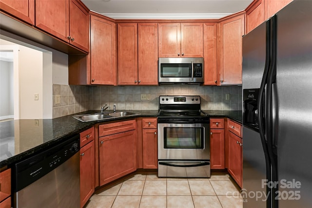 9 Kenilworth Knl, Asheville, NC 28805 - kitchen featuring stainless steel appliances, light tile patterned floors, decorative backsplash, brown cabinets, and dark stone counters