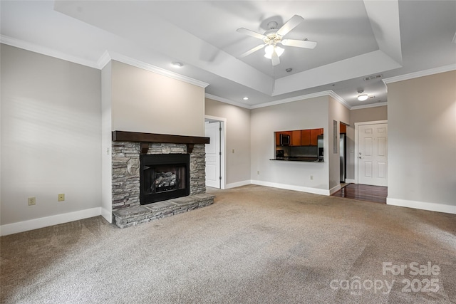 9 Kenilworth Knl, Asheville, NC 28805 - unfurnished living room with a ceiling fan, a raised ceiling, carpet floors, a stone fireplace, and ornamental molding