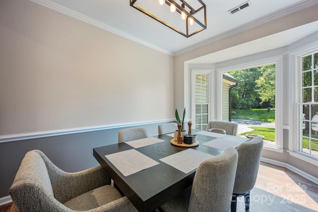 1045 Fairway Ridge Rd NW, Concord, NC 28027 - dining room with healthy amount of natural light, crown molding, a chandelier, and wood finished floors