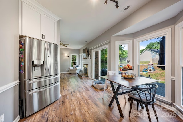 1045 Fairway Ridge Rd NW, Concord, NC 28027 - dining room with wood finished floors, plenty of natural light, a glass covered fireplace, and ceiling fan