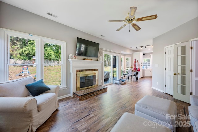 1045 Fairway Ridge Rd NW, Concord, NC 28027 - living room with wood finished floors, healthy amount of natural light, track lighting, and a brick fireplace