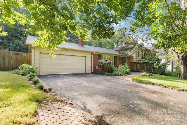 6921 Thermal Rd, Charlotte, NC 28211 - split level home featuring a chimney, brick siding, an attached garage, and asphalt driveway