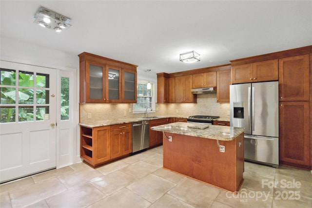 6921 Thermal Rd, Charlotte, NC 28211 - kitchen featuring appliances with stainless steel finishes, under cabinet range hood, backsplash, and light stone counters