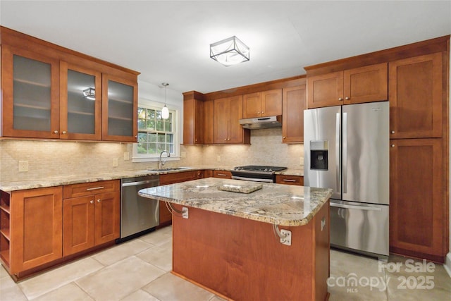 6921 Thermal Rd, Charlotte, NC 28211 - kitchen featuring appliances with stainless steel finishes, under cabinet range hood, light stone countertops, brown cabinets, and decorative backsplash