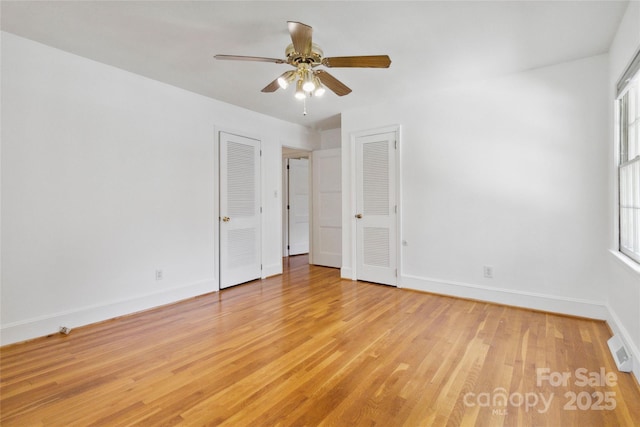 6921 Thermal Rd, Charlotte, NC 28211 - unfurnished bedroom with light wood finished floors, multiple windows, multiple closets, and ceiling fan