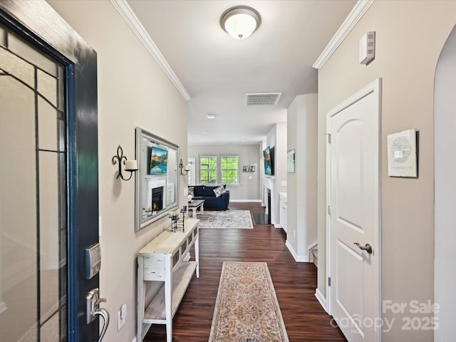 15614 Aviary Orchard Way, Charlotte, NC 28278 - foyer entrance with dark wood finished floors, arched walkways, crown molding, and a lit fireplace