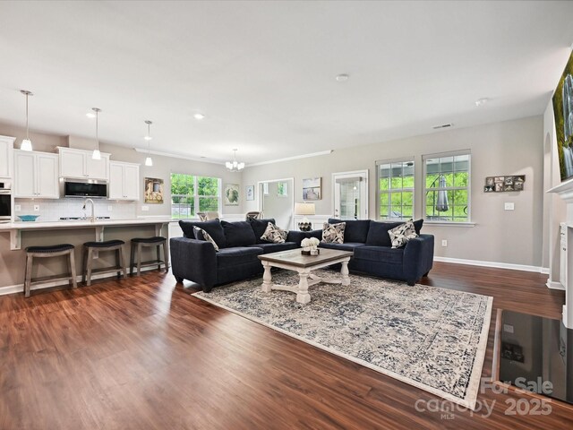 15614 Aviary Orchard Way, Charlotte, NC 28278 - living room with dark wood-style flooring and a chandelier