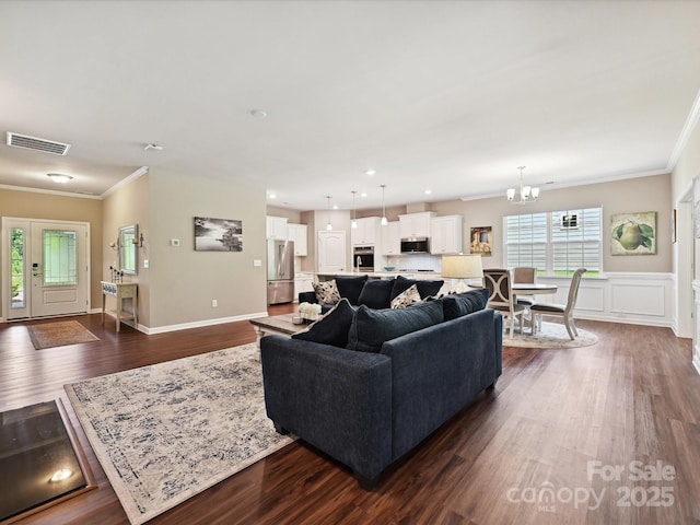 15614 Aviary Orchard Way, Charlotte, NC 28278 - living room featuring crown molding, a chandelier, dark wood-style floors, a wainscoted wall, and recessed lighting