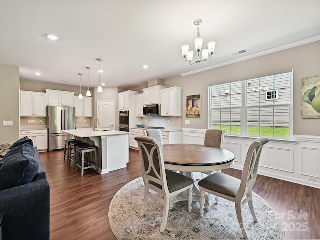15614 Aviary Orchard Way, Charlotte, NC 28278 - dining room featuring a chandelier, wainscoting, ornamental molding, recessed lighting, and dark wood-style floors