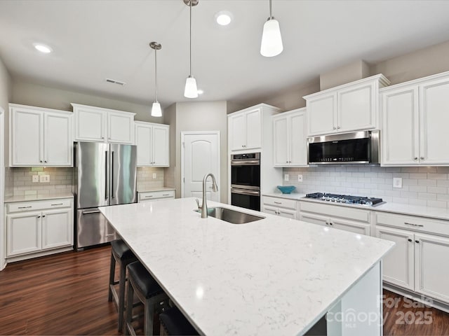 15614 Aviary Orchard Way, Charlotte, NC 28278 - kitchen featuring stainless steel appliances, a center island with sink, decorative backsplash, white cabinetry, and recessed lighting