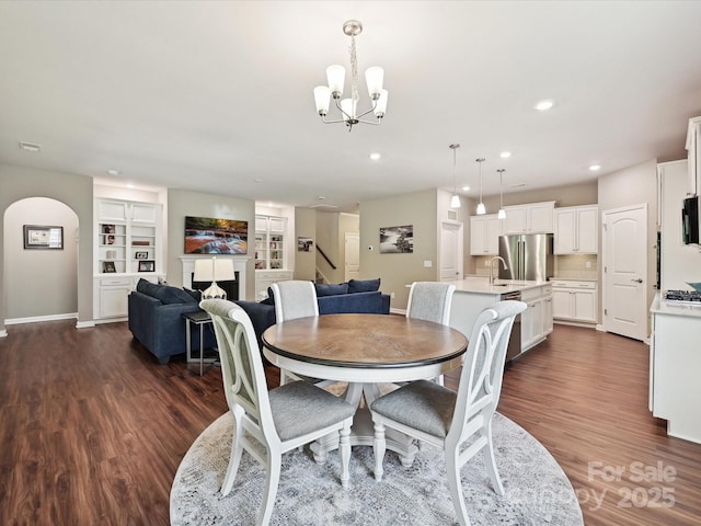 15614 Aviary Orchard Way, Charlotte, NC 28278 - dining room with a chandelier, dark wood-type flooring, recessed lighting, arched walkways, and stairs