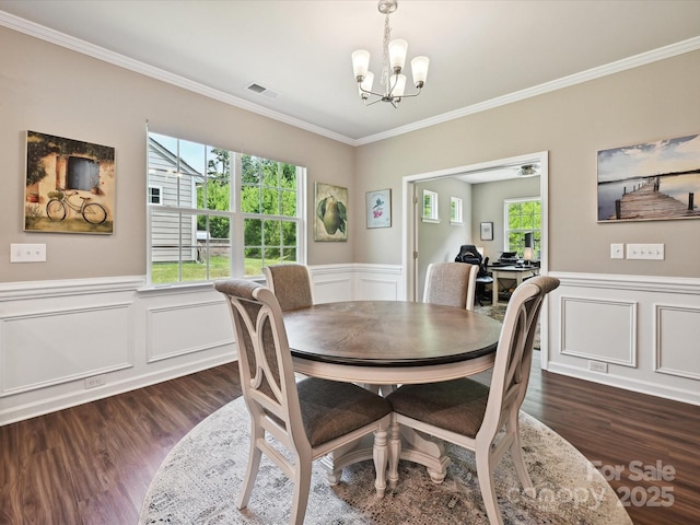 15614 Aviary Orchard Way, Charlotte, NC 28278 - dining area featuring crown molding, a chandelier, dark wood-type flooring, a wainscoted wall, and a decorative wall