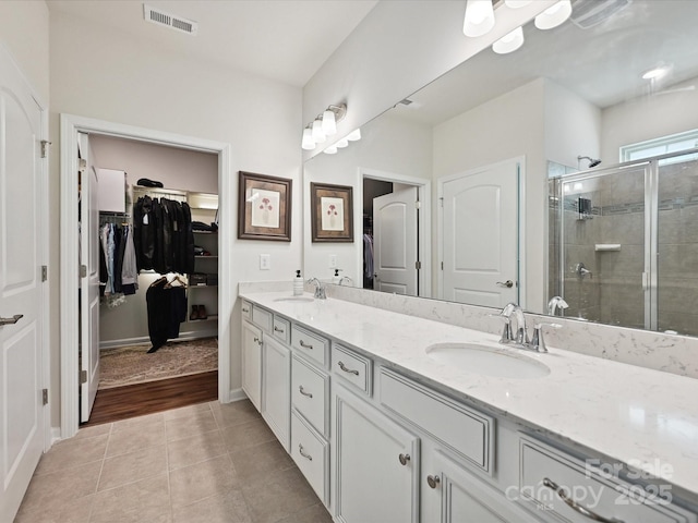 15614 Aviary Orchard Way, Charlotte, NC 28278 - bathroom with double vanity, a walk in closet, a stall shower, and tile patterned floors