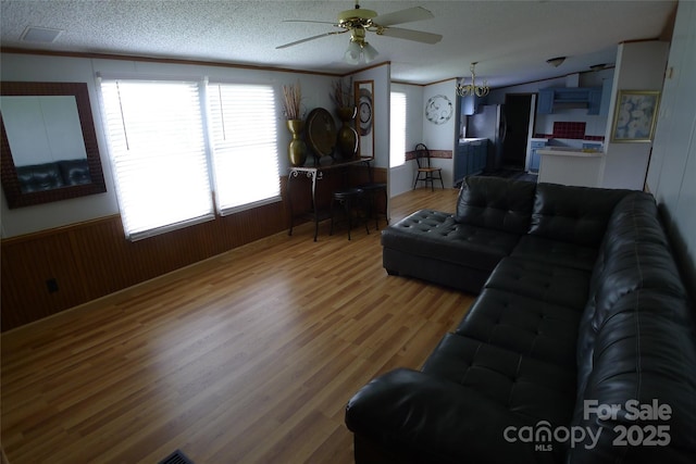 236 Boxwood Church Rd, Mocksville, NC 27028 - living room featuring ceiling fan, light wood-style flooring, wood walls, and a wainscoted wall