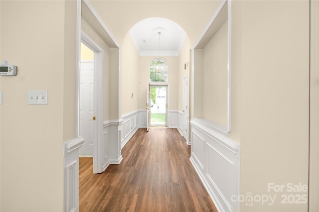 14103 Hiawatha Ct, Huntersville, NC 28078 - hallway featuring dark wood-style floors, crown molding, arched walkways, a decorative wall, and wainscoting