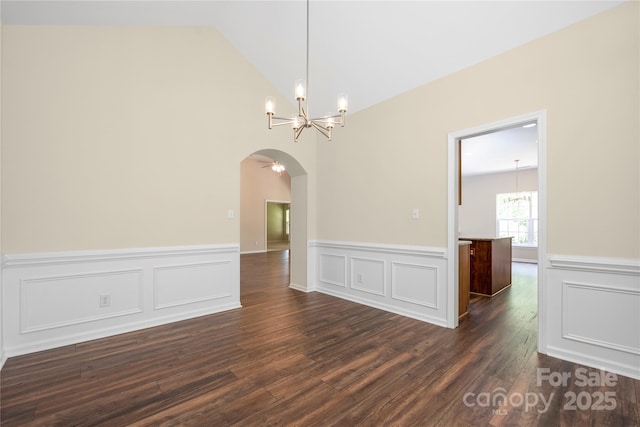 14103 Hiawatha Ct, Huntersville, NC 28078 - empty room featuring a chandelier, arched walkways, dark wood-type flooring, wainscoting, and lofted ceiling