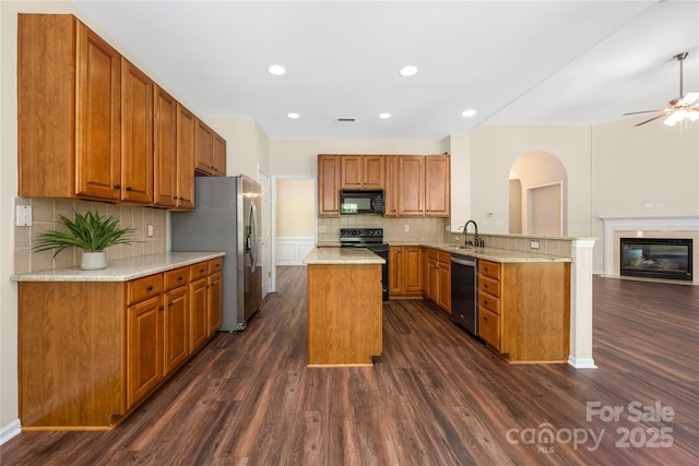 14103 Hiawatha Ct, Huntersville, NC 28078 - kitchen with black appliances, a peninsula, dark wood-style floors, arched walkways, and decorative backsplash