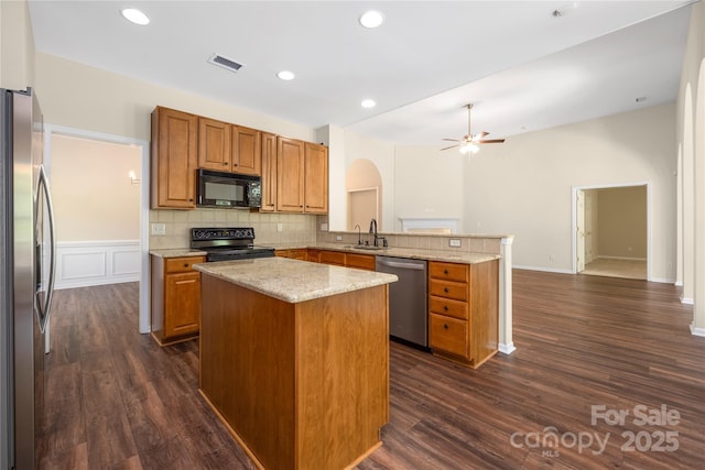14103 Hiawatha Ct, Huntersville, NC 28078 - kitchen with black appliances, a peninsula, arched walkways, a ceiling fan, and light stone countertops