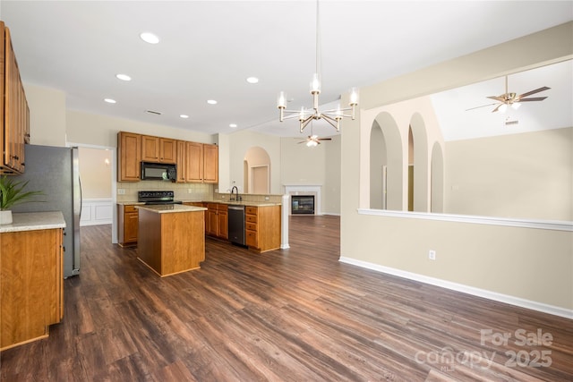 14103 Hiawatha Ct, Huntersville, NC 28078 - kitchen featuring appliances with stainless steel finishes, open floor plan, a center island, brown cabinetry, and dark wood-style flooring