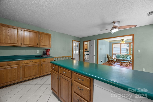 324 Swamp Fox Dr, Fort Mill, SC 29715 - kitchen with ceiling fan, brown cabinetry, a textured ceiling, light tile patterned flooring, and dark countertops