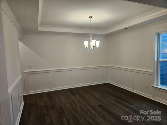 8231 Annsborough Dr NW, Concord, NC 28027 - unfurnished dining area featuring a tray ceiling, a decorative wall, dark wood finished floors, crown molding, and a chandelier
