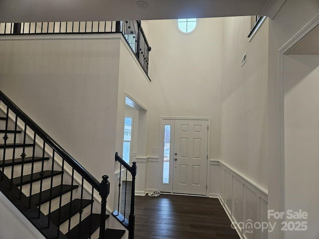 8231 Annsborough Dr NW, Concord, NC 28027 - foyer entrance featuring dark wood-type flooring, a wainscoted wall, stairs, and a towering ceiling