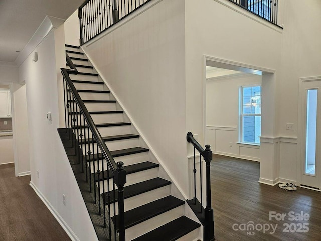 8231 Annsborough Dr NW, Concord, NC 28027 - stairs featuring wood finished floors, ornamental molding, wainscoting, and a towering ceiling