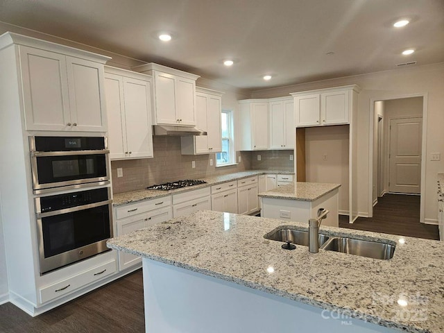 8231 Annsborough Dr NW, Concord, NC 28027 - kitchen featuring dark wood-style floors, white cabinets, stainless steel appliances, decorative backsplash, and recessed lighting
