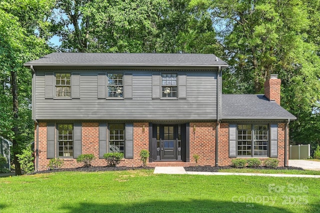 811 Ashmeade Rd, Charlotte, NC 28211 - colonial home featuring a front yard, a chimney, brick siding, and a shingled roof