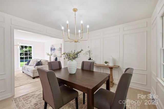 811 Ashmeade Rd, Charlotte, NC 28211 - dining area featuring a decorative wall, a chandelier, and light wood finished floors