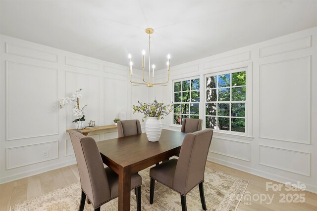 811 Ashmeade Rd, Charlotte, NC 28211 - dining area featuring a decorative wall, a chandelier, and light wood-style floors