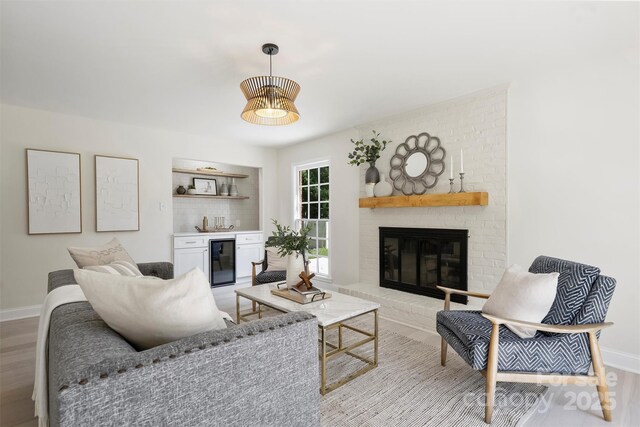 811 Ashmeade Rd, Charlotte, NC 28211 - living room featuring beverage cooler, a dry bar, light wood-style floors, and a brick fireplace