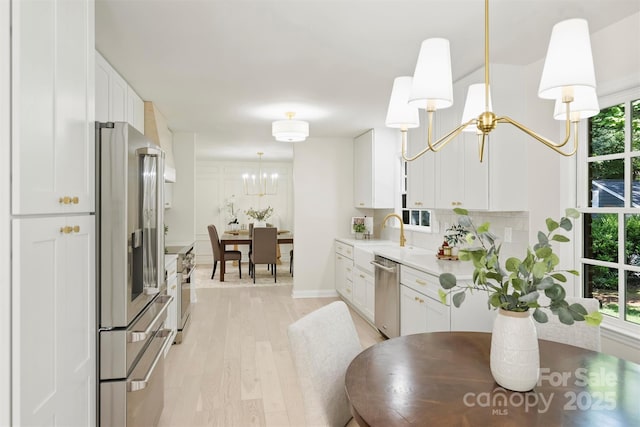811 Ashmeade Rd, Charlotte, NC 28211 - kitchen with a chandelier, high quality appliances, light wood finished floors, and white cabinetry
