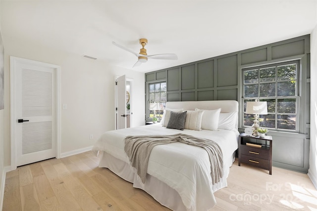 811 Ashmeade Rd, Charlotte, NC 28211 - bedroom with a decorative wall, multiple windows, light wood-style flooring, and a ceiling fan