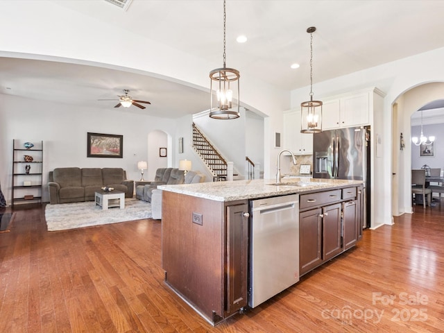 1009 Hampton Grove Rd, Waxhaw, NC 28173 - kitchen featuring dishwasher, arched walkways, wood finished floors, white cabinets, and hanging light fixtures