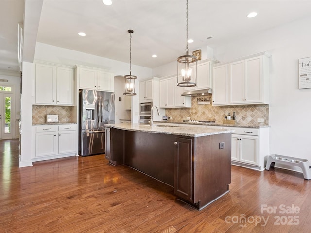 1009 Hampton Grove Rd, Waxhaw, NC 28173 - kitchen with appliances with stainless steel finishes, tasteful backsplash, white cabinetry, dark wood-type flooring, and an island with sink