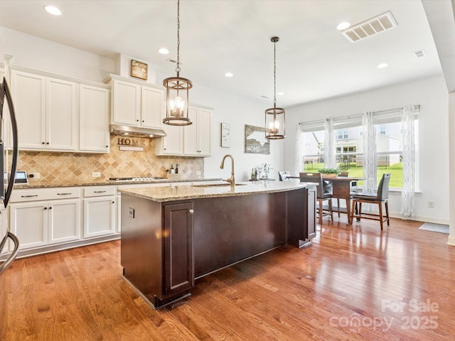 1009 Hampton Grove Rd, Waxhaw, NC 28173 - kitchen with tasteful backsplash, stainless steel gas stovetop, white cabinets, light stone countertops, and recessed lighting