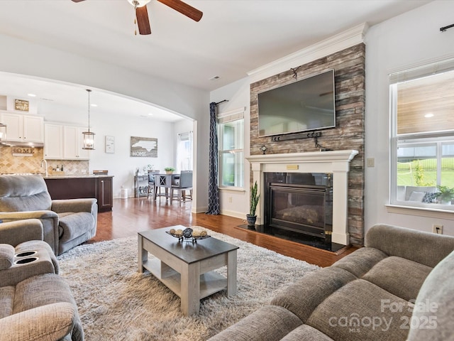 1009 Hampton Grove Rd, Waxhaw, NC 28173 - living room featuring ceiling fan, dark wood-type flooring, arched walkways, and a glass covered fireplace