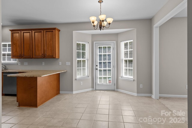 4519 Rock Stream Dr, Charlotte, NC 28269 - kitchen with stainless steel dishwasher, brown cabinetry, a chandelier, a peninsula, and hanging light fixtures