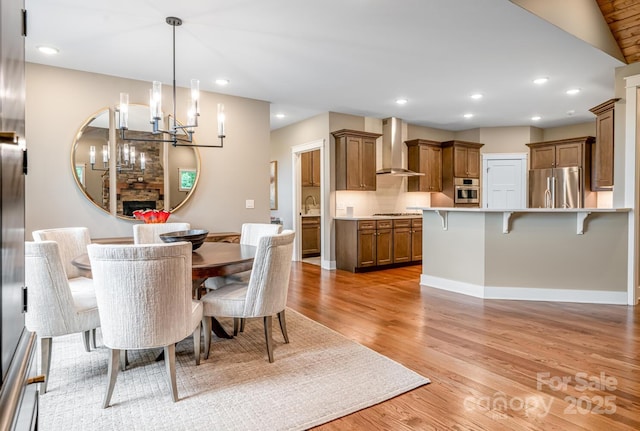 807 Hollybrook Dr, Flat Rock, NC 28731 - dining space with light wood-style flooring, a chandelier, recessed lighting, and a fireplace