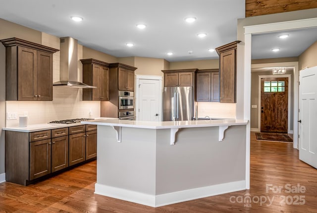 807 Hollybrook Dr, Flat Rock, NC 28731 - kitchen with appliances with stainless steel finishes, wall chimney exhaust hood, a peninsula, a breakfast bar, and recessed lighting