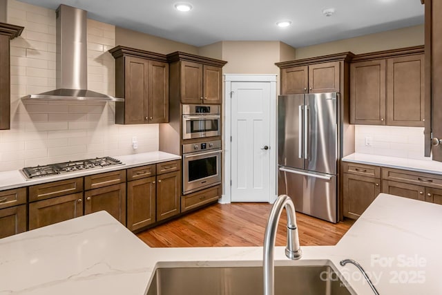 807 Hollybrook Dr, Flat Rock, NC 28731 - kitchen with appliances with stainless steel finishes, wall chimney exhaust hood, light wood-style flooring, tasteful backsplash, and recessed lighting